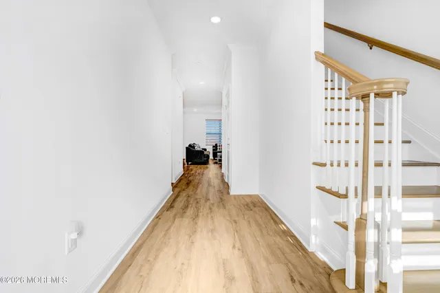 a view of a hallway with wooden floor and staircase