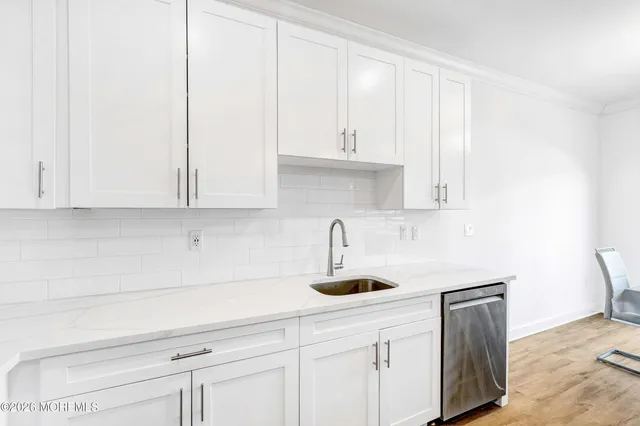 a kitchen with white cabinets and sink