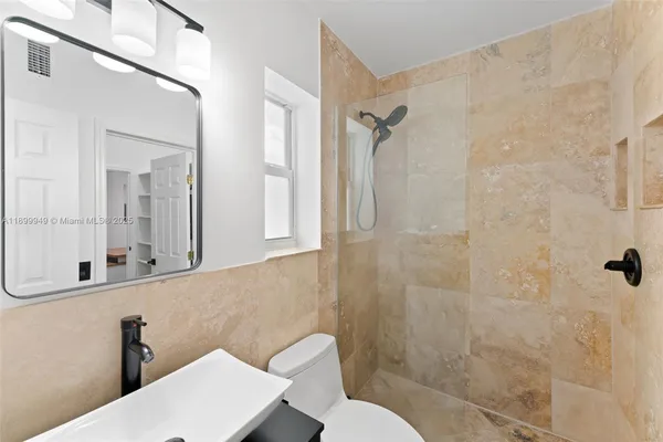 a bathroom with a toilet a sink and mirror