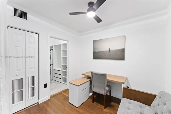 a workspace with wooden floor and a chandelier fan