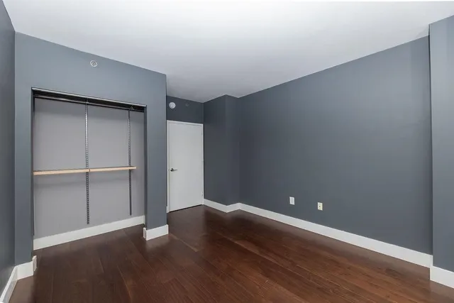 a view of an empty room with wooden floor