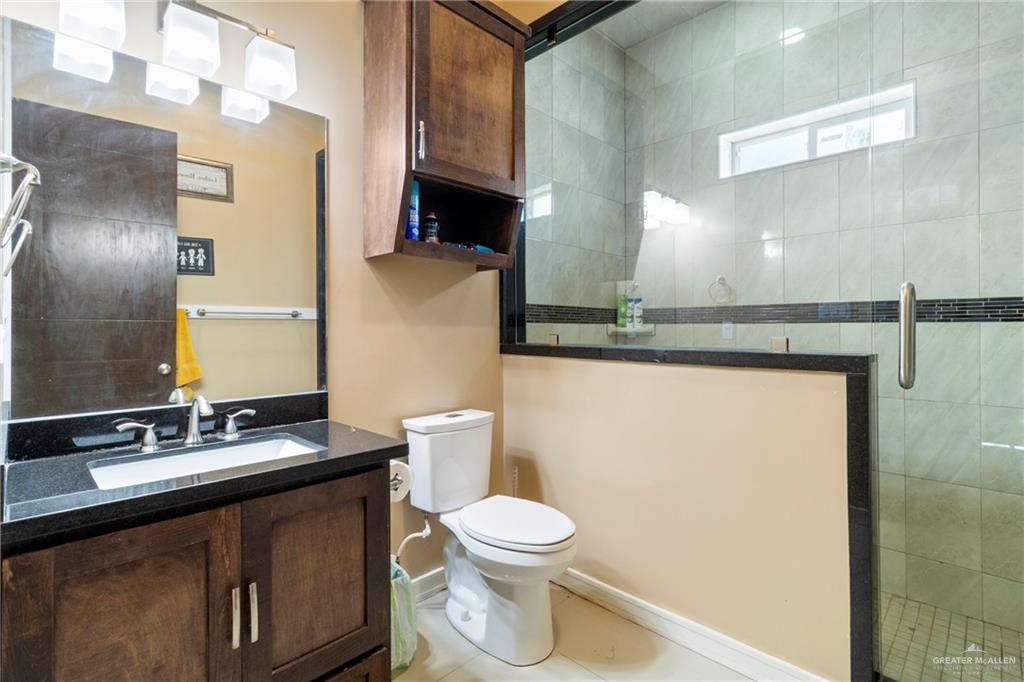 10821 North Moorefield Road Mission, TX 78574 - Photo 14 of 31 Bathroom featuring vanity, toilet, tile patterned floors, and walk in shower