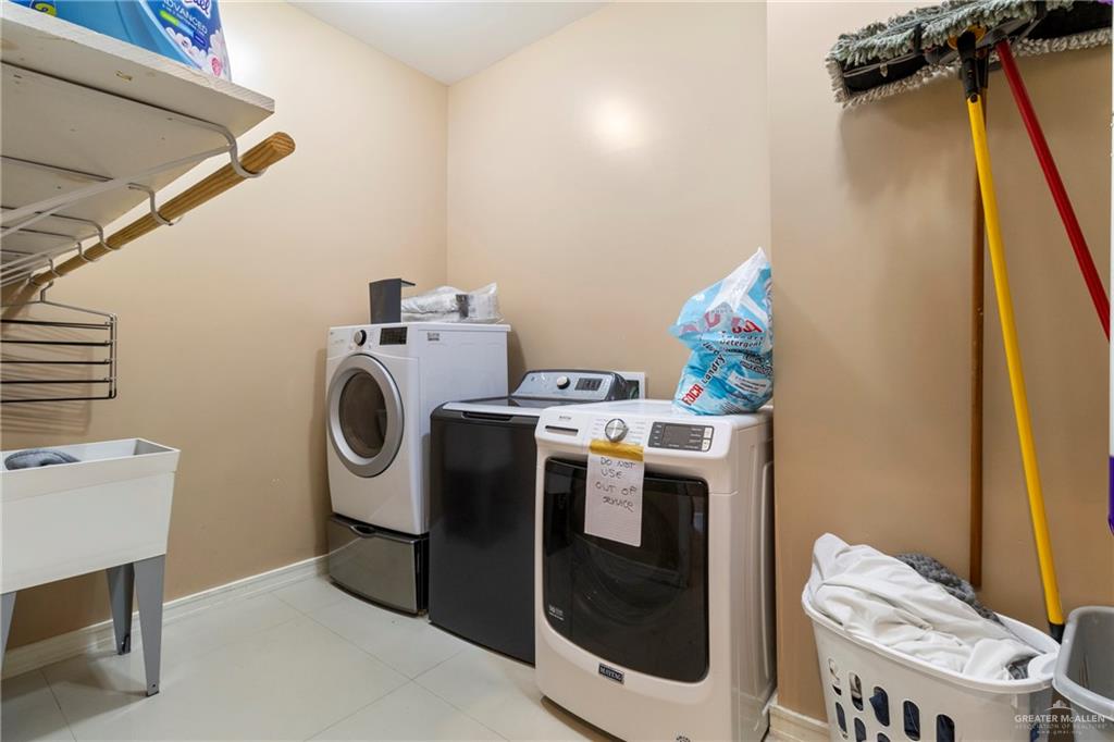 10821 North Moorefield Road Mission, TX 78574 - Photo 20 of 31 Laundry area with light tile patterned floors and washing machine and clothes dryer