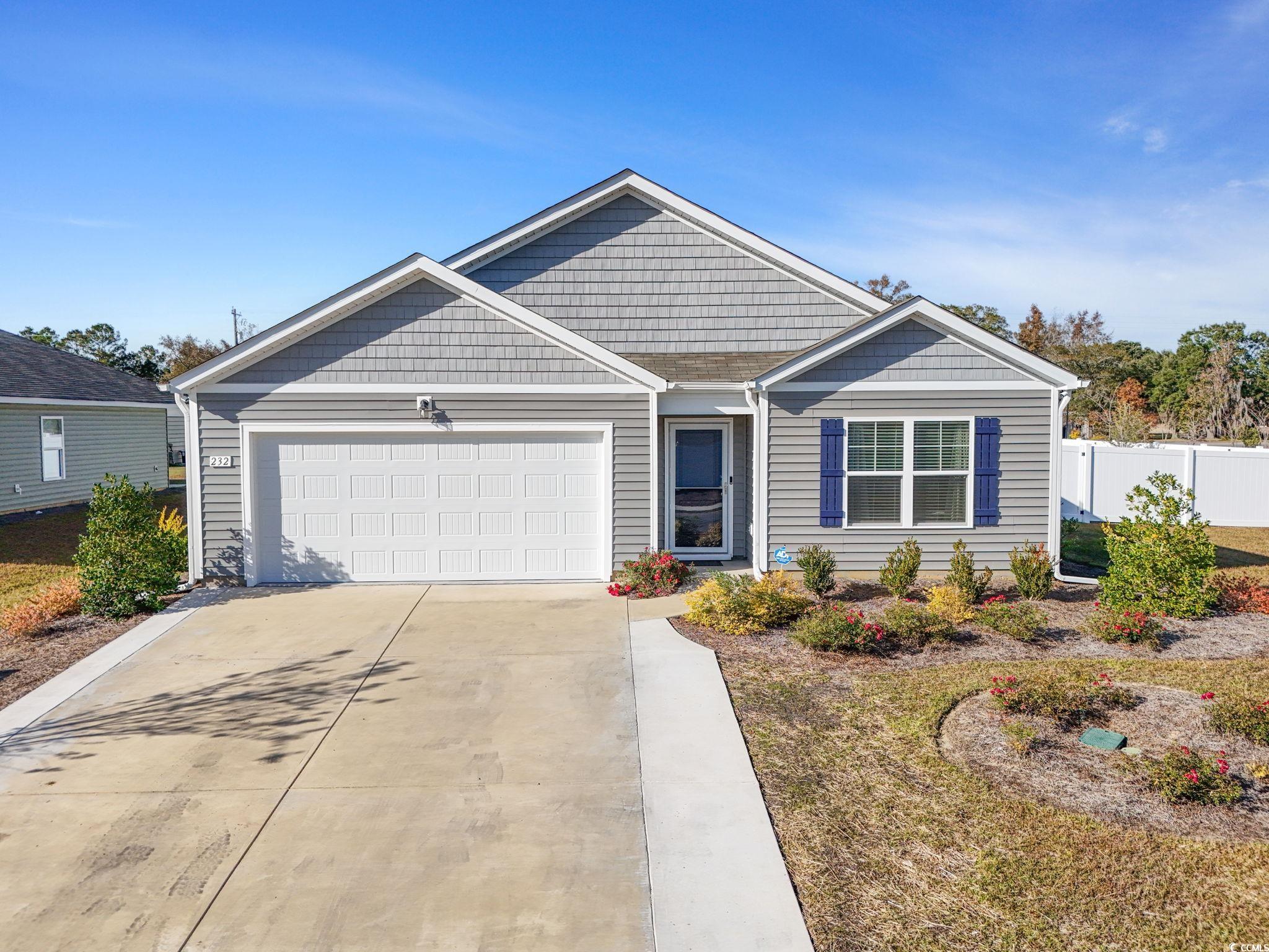 View of front of property with concrete driveway and a garage