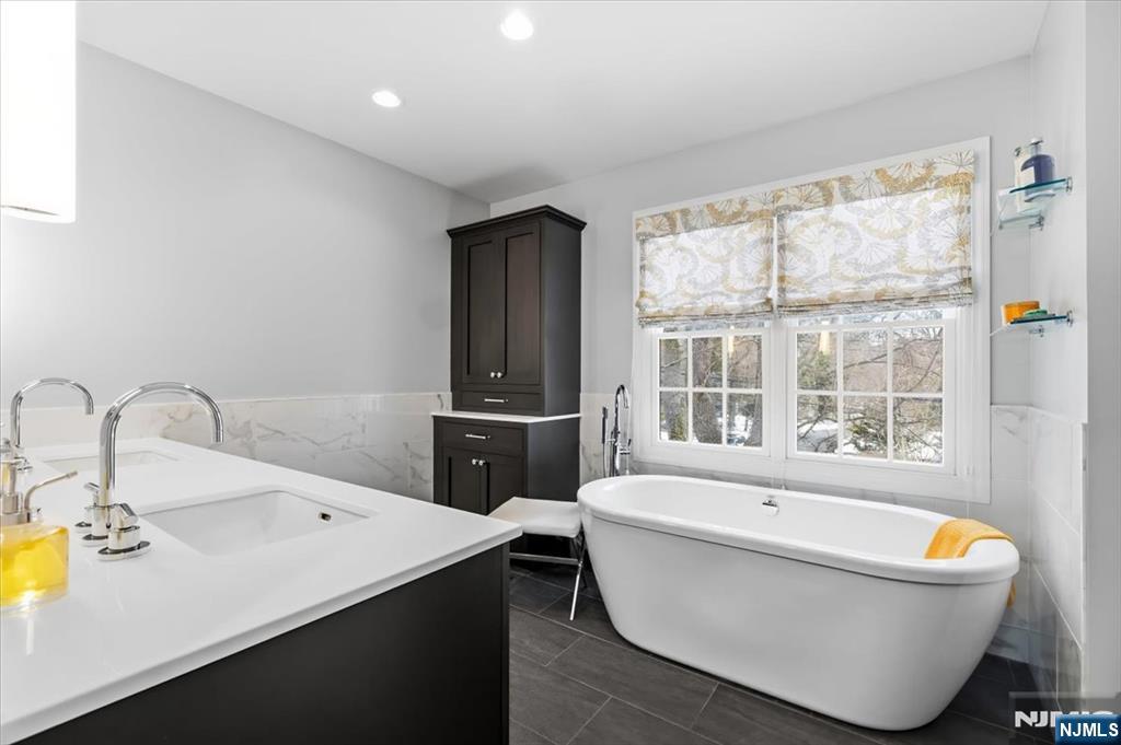 4 Lindeman Avenue Closter, NJ 07624 - Photo 19 of 36 a bathroom with a bathtub sink and mirror