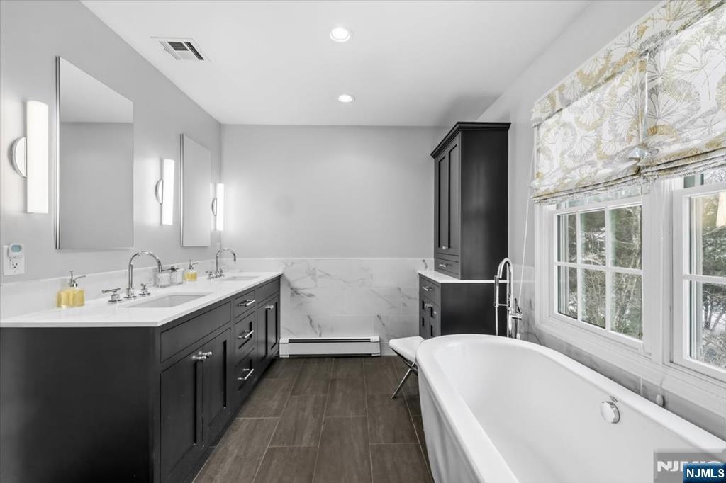4 Lindeman Avenue Closter, NJ 07624 - Photo 20 of 36 a bathroom with a tub sink and mirror