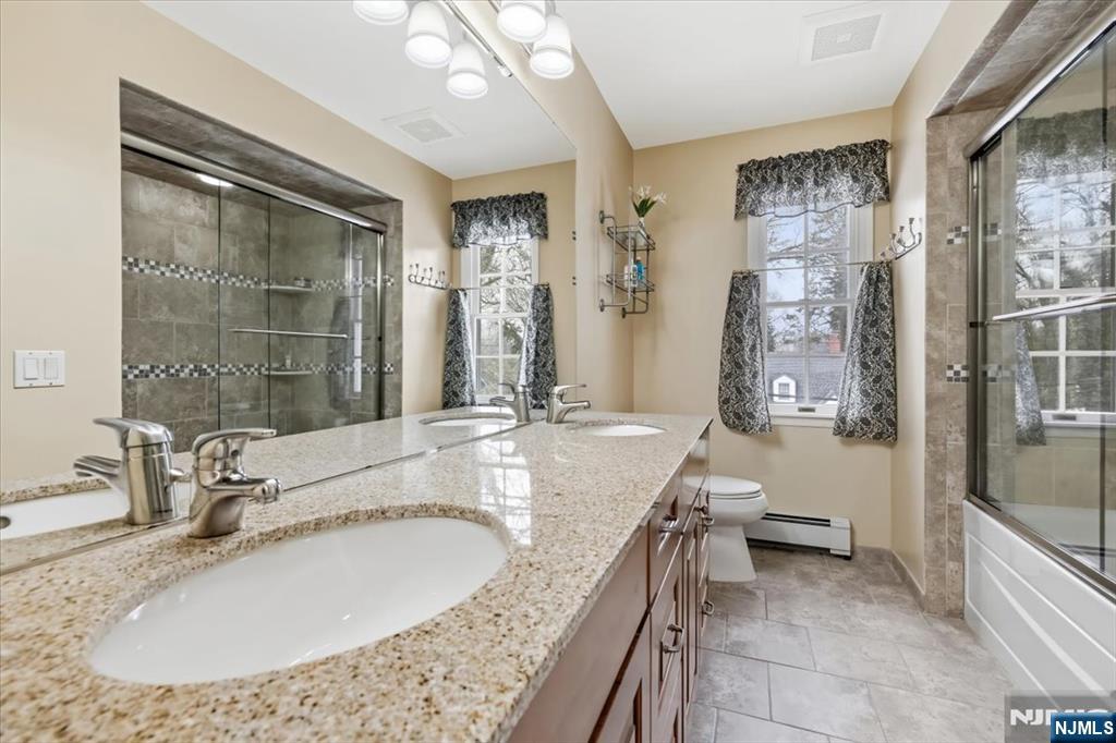 4 Lindeman Avenue Closter, NJ 07624 - Photo 27 of 36 a bathroom with a granite countertop sink a toilet a mirror and shower