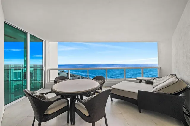 a living room with furniture a flat screen tv and a floor to ceiling window