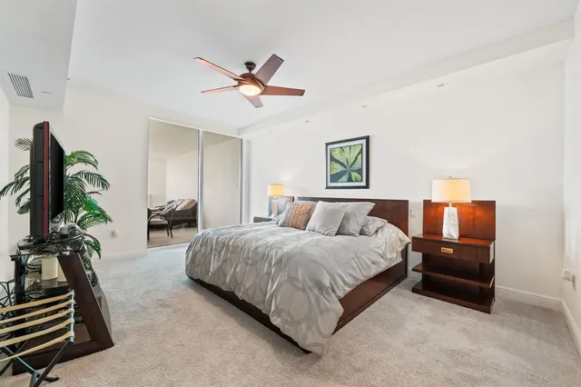 a spacious bedroom with a bed and a chandelier