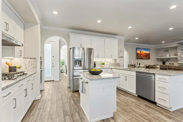 a kitchen with granite countertop sink stove and dining table
