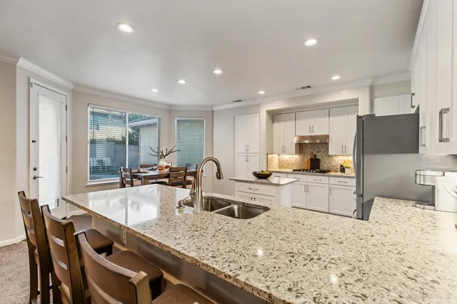 a kitchen with stainless steel appliances granite countertop a sink dishwasher and cabinets with wooden floor