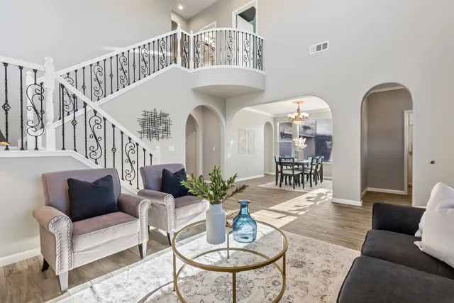 a view of a dining room with furniture a chandelier and wooden floor