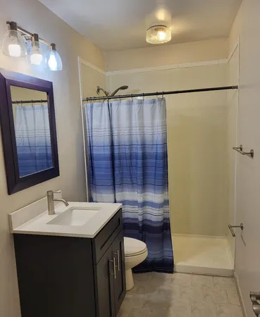 a bathroom with a sink toilet and shower
