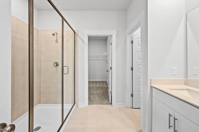 a bathroom with a granite countertop sink a mirror and shower