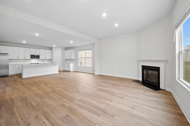 a view of an empty room with window and wooden floor