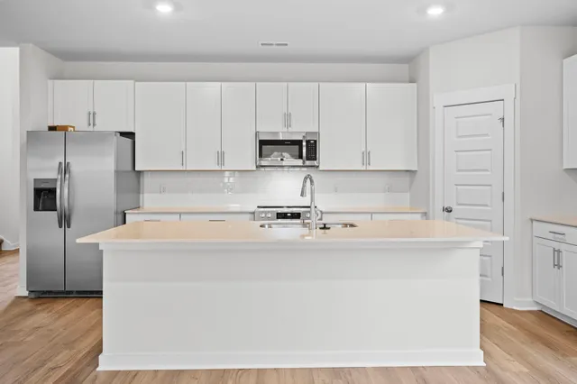 a view of a kitchen with cabinets and stainless steel appliances