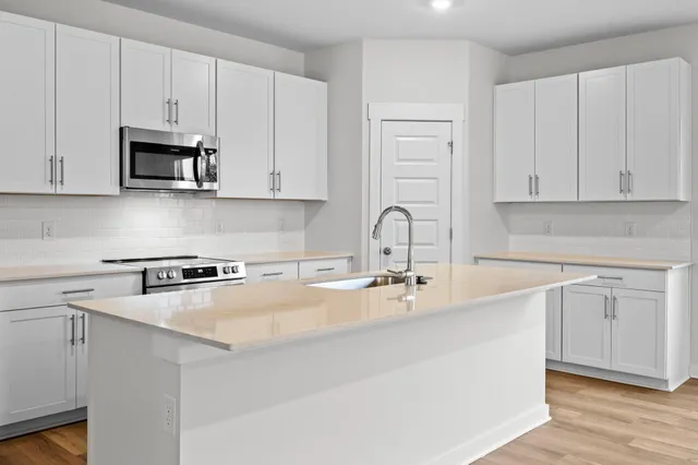 a kitchen with stainless steel appliances granite countertop a sink a stove and a refrigerator