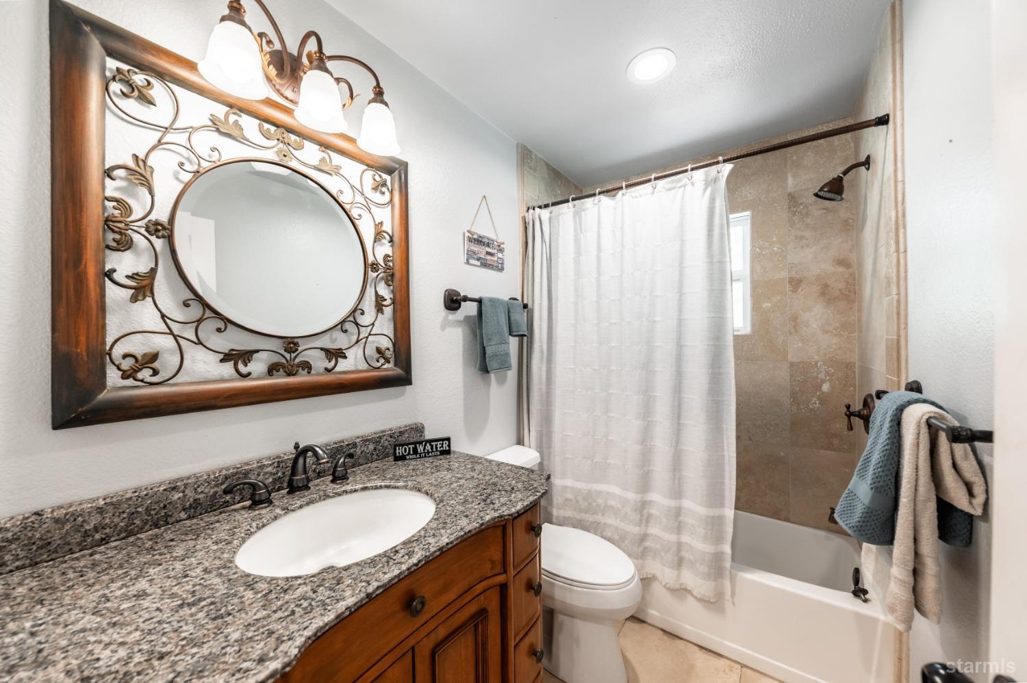 15740 Highway 89 Markleeville, CA 96120 - Photo 17 of 24 a bathroom with a granite countertop sink toilet and a mirror