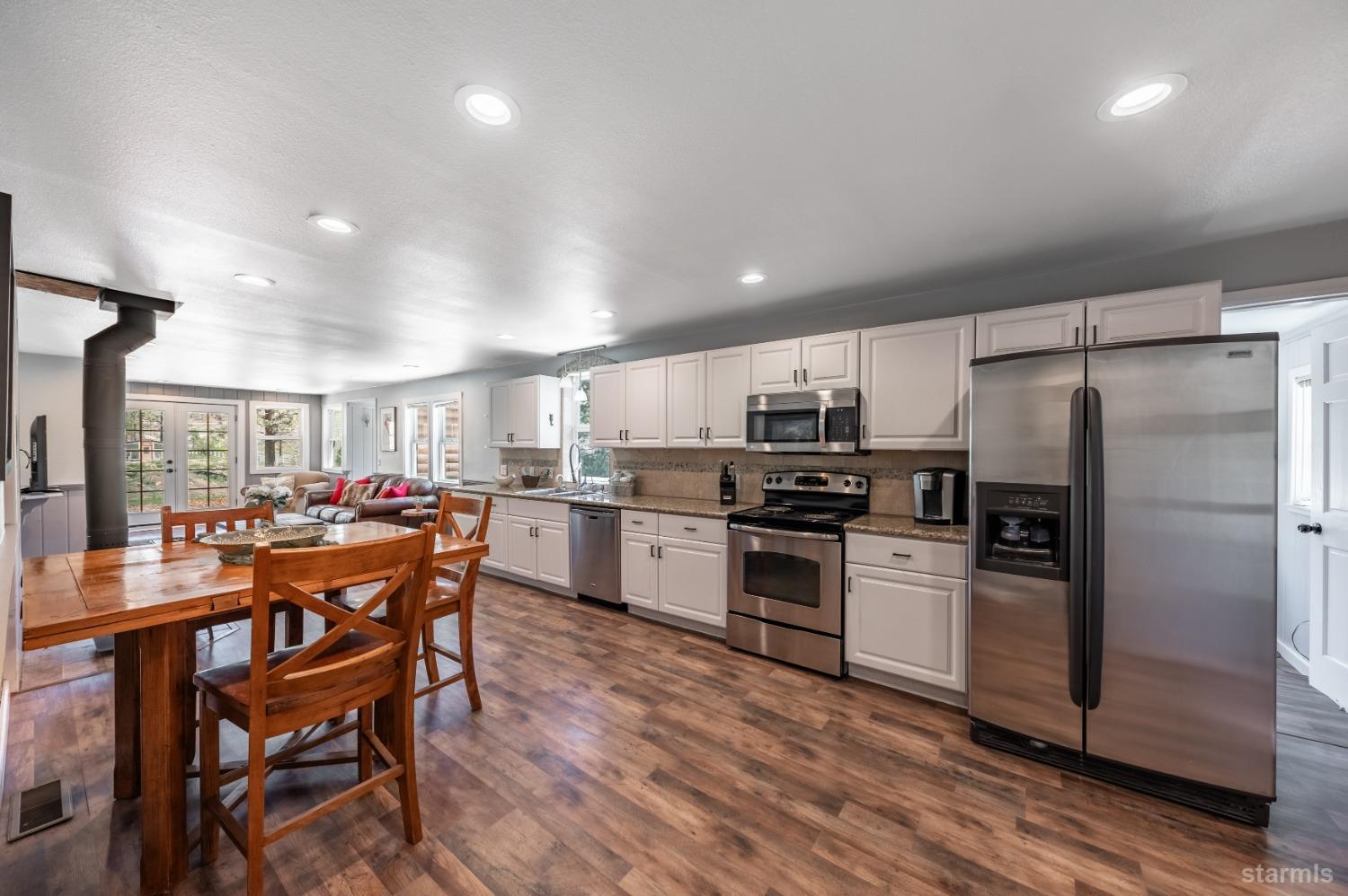 15740 Highway 89 Markleeville, CA 96120 - Photo 5 of 24 a kitchen with a table chairs refrigerator and microwave