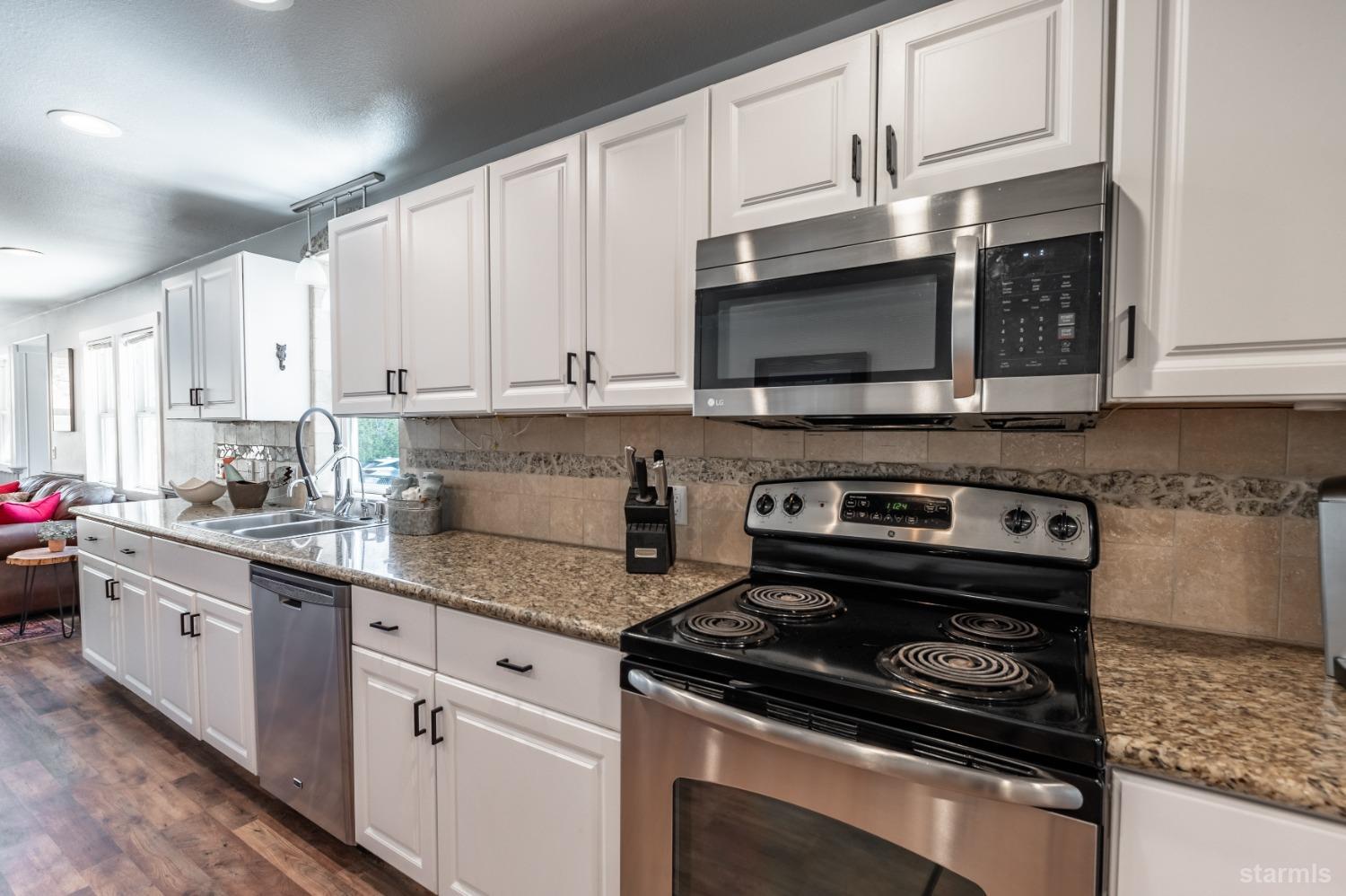 15740 Highway 89 Markleeville, CA 96120 - Photo 6 of 24 a kitchen with granite countertop a stove top oven microwave and cabinets