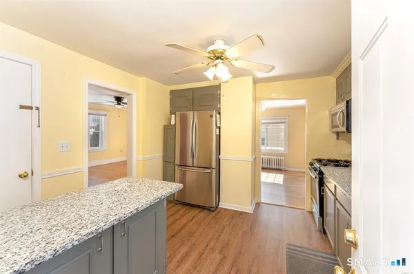 a view of empty room with wooden floor and fan