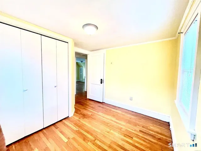 a view of a big room with wooden floor and a window