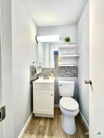 a bathroom with a granite countertop toilet sink and mirror