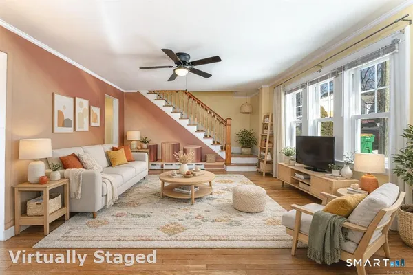 a living room with furniture floor to ceiling window and a flat screen tv