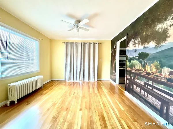 a dining room with furniture a rug and a floor to ceiling window