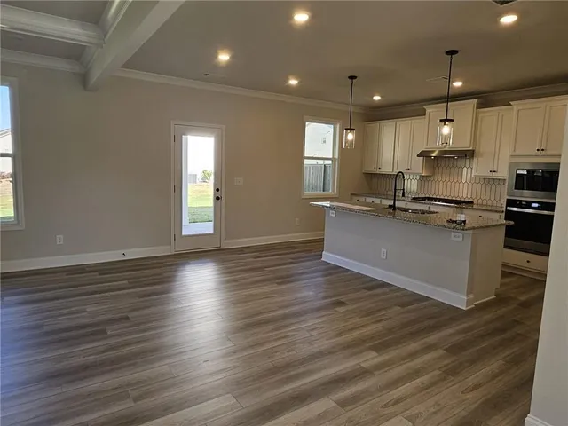a large kitchen with stainless steel appliances granite countertop a stove a sink and a large refrigerator
