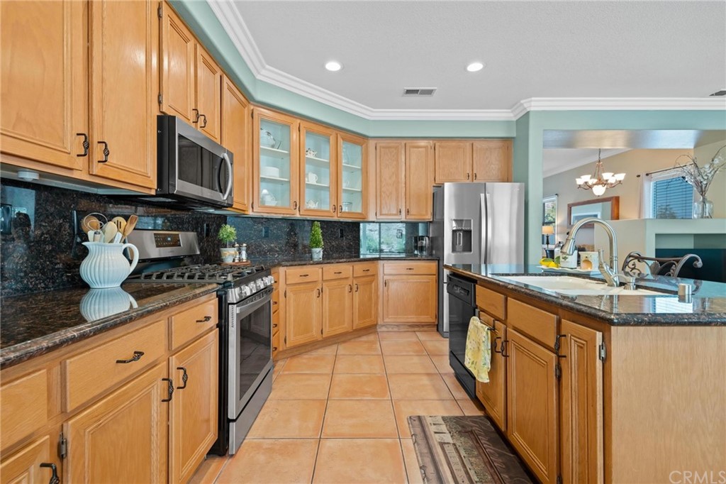 20803 Millbrook Street Riverside, CA 92508 - Photo 15 of 44 a kitchen with stainless steel appliances granite countertop a stove a sink dishwasher and a refrigerator