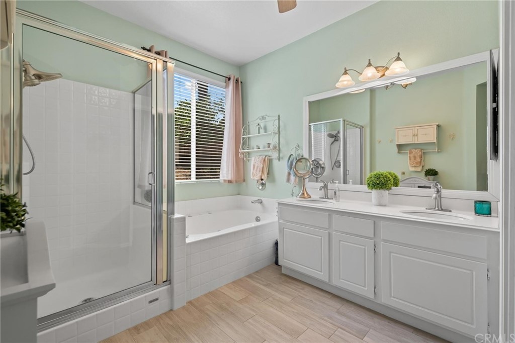 20803 Millbrook Street Riverside, CA 92508 - Photo 22 of 44 a spacious bathroom with a double vanity sink a large mirror a bathtub and next to a window