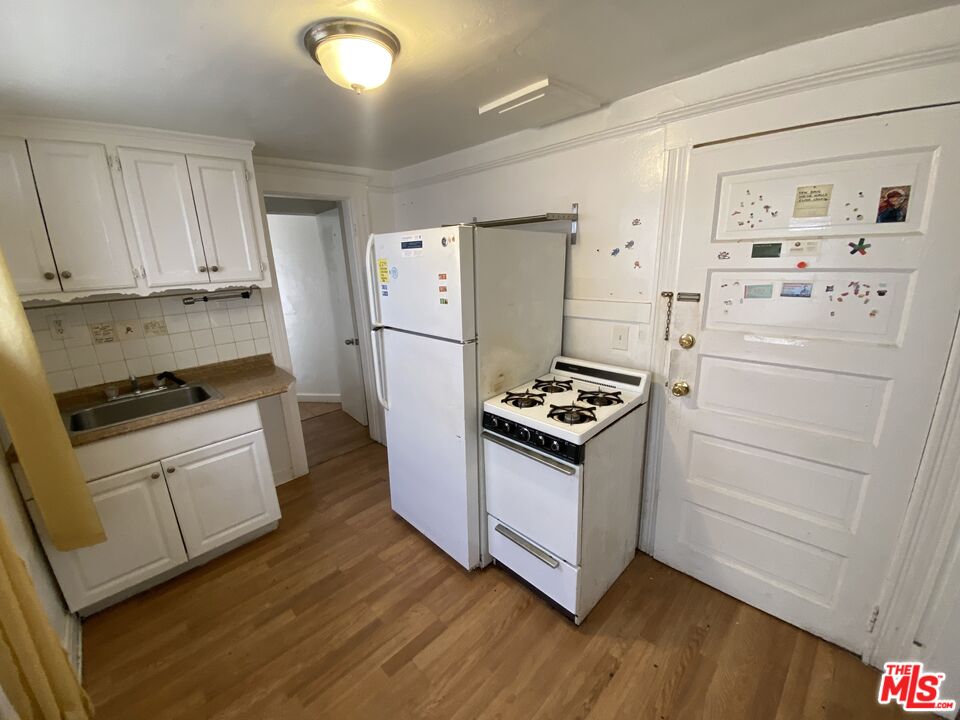 44 Rose Avenue Venice, CA 90291 - Photo 20 of 33 a kitchen with a refrigerator stove and white cabinets