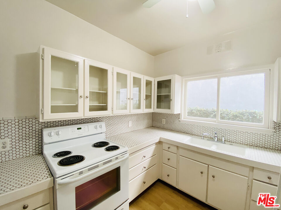 44 Rose Avenue Venice, CA 90291 - Photo 33 of 33 a kitchen with granite countertop a stove a sink and a microwave