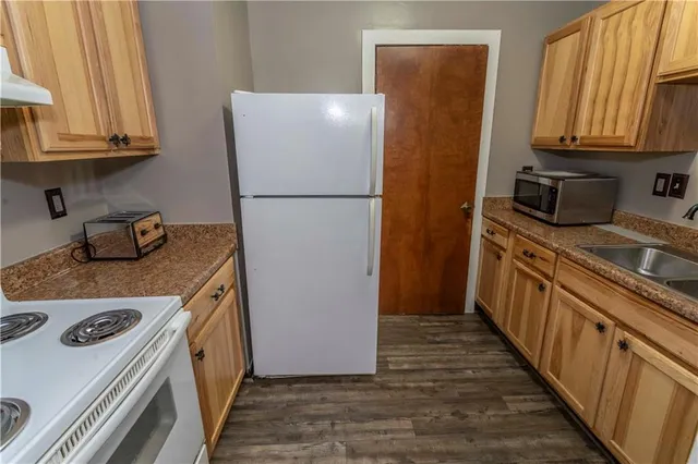 a kitchen with a refrigerator a stove a sink and cabinets