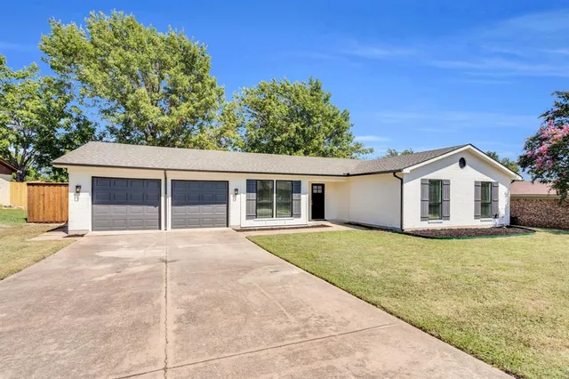 a view of a house with a yard and potted plants