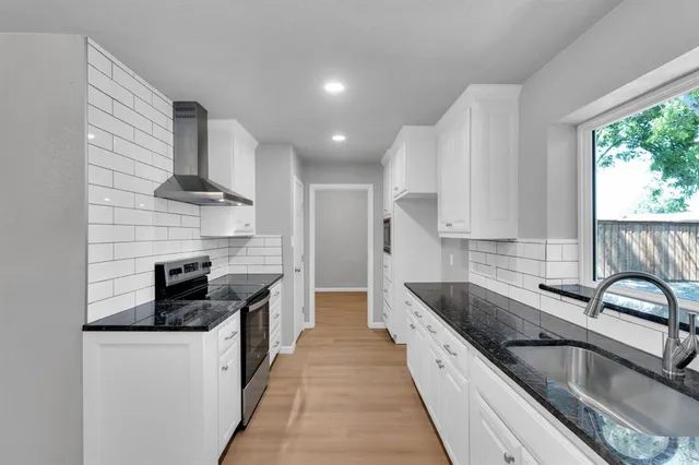 a kitchen with stainless steel appliances granite countertop a sink and a stove
