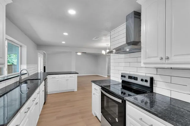 a kitchen with granite countertop cabinets stainless steel appliances and a counter space