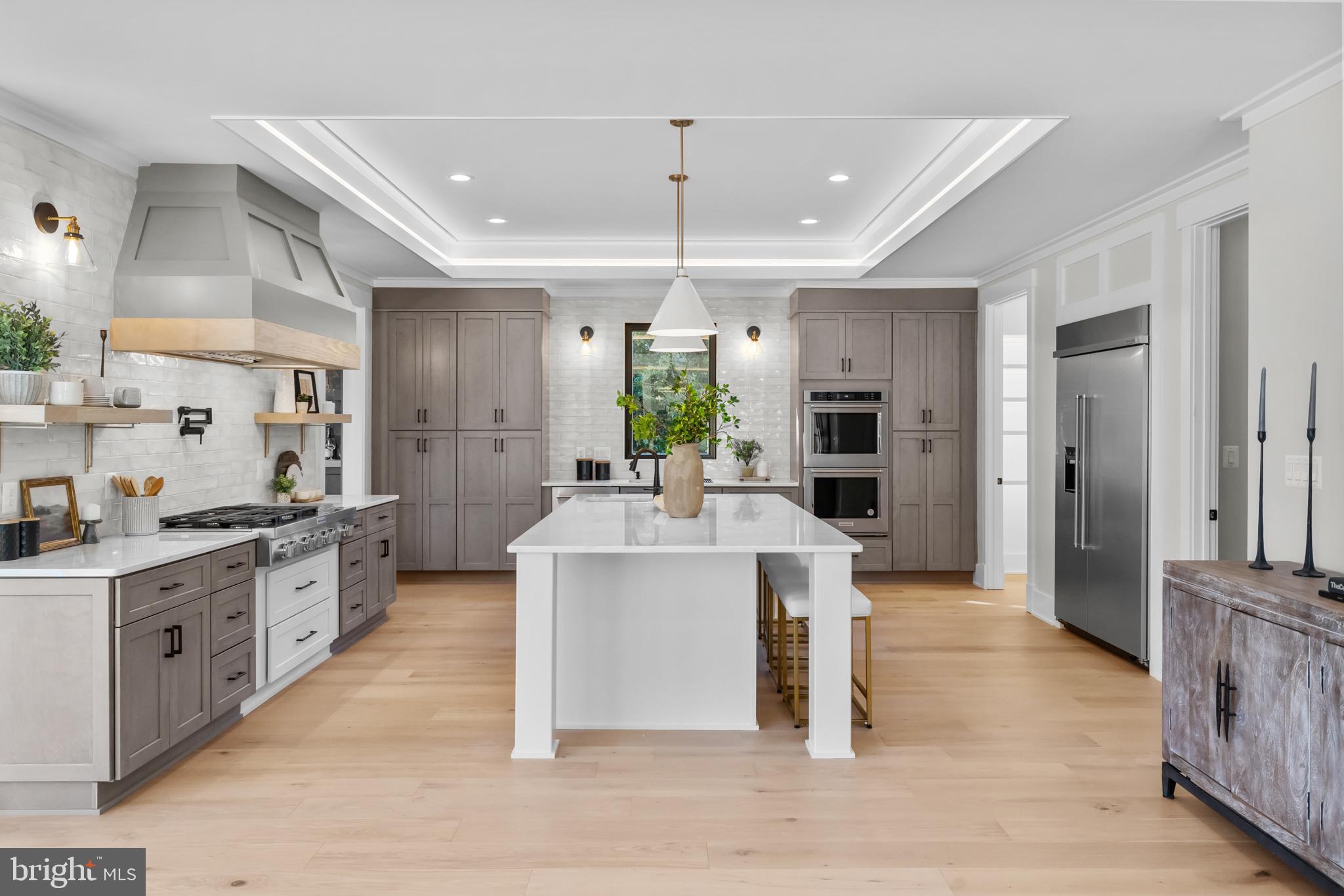 1852 Griffith Road Falls Church, VA 22043 - Photo 26 of 110 a large white kitchen with stainless steel appliances kitchen island granite countertop a large stove a sink dishwasher and a refrigerator with wooden floor