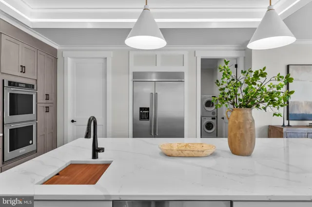a view of an empty room with a window and a kitchen
