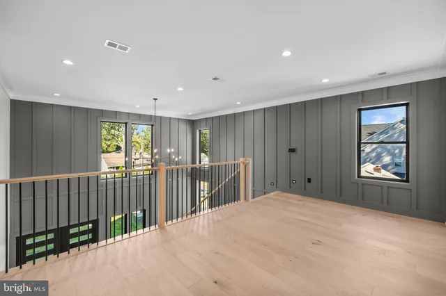 a view of a livingroom with a ceiling fan & windows