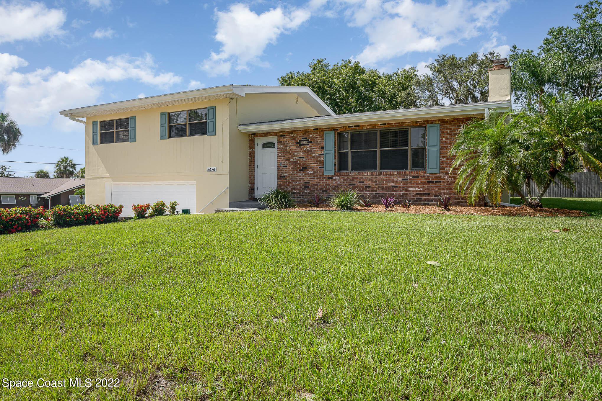 2676 Lemon Street Northeast Palm Bay, FL 32905 - Photo 1 of 35 a front view of a house with a yard and garage
