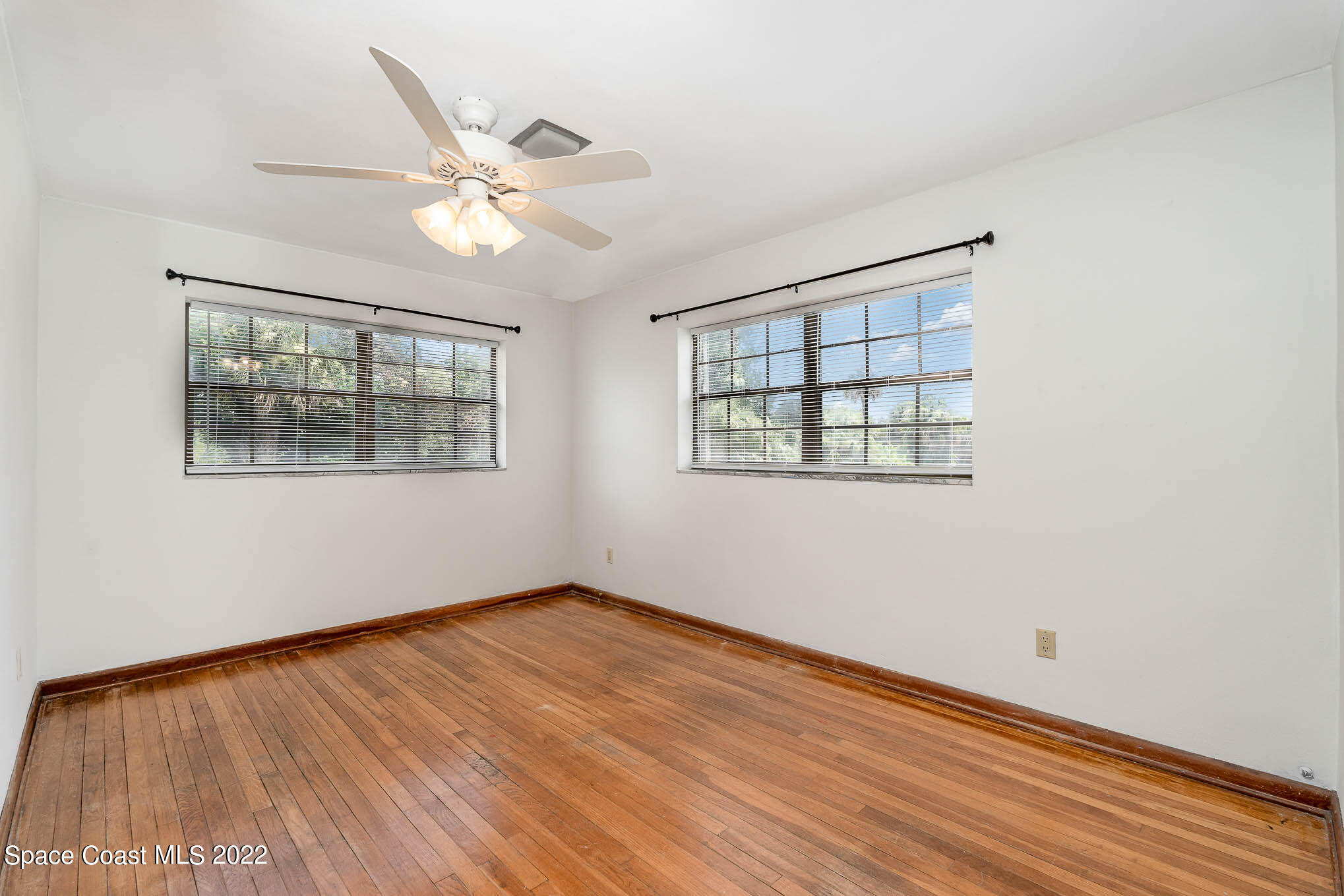 2676 Lemon Street Northeast Palm Bay, FL 32905 - Photo 21 of 35 a view of an empty room with wooden floor and a window