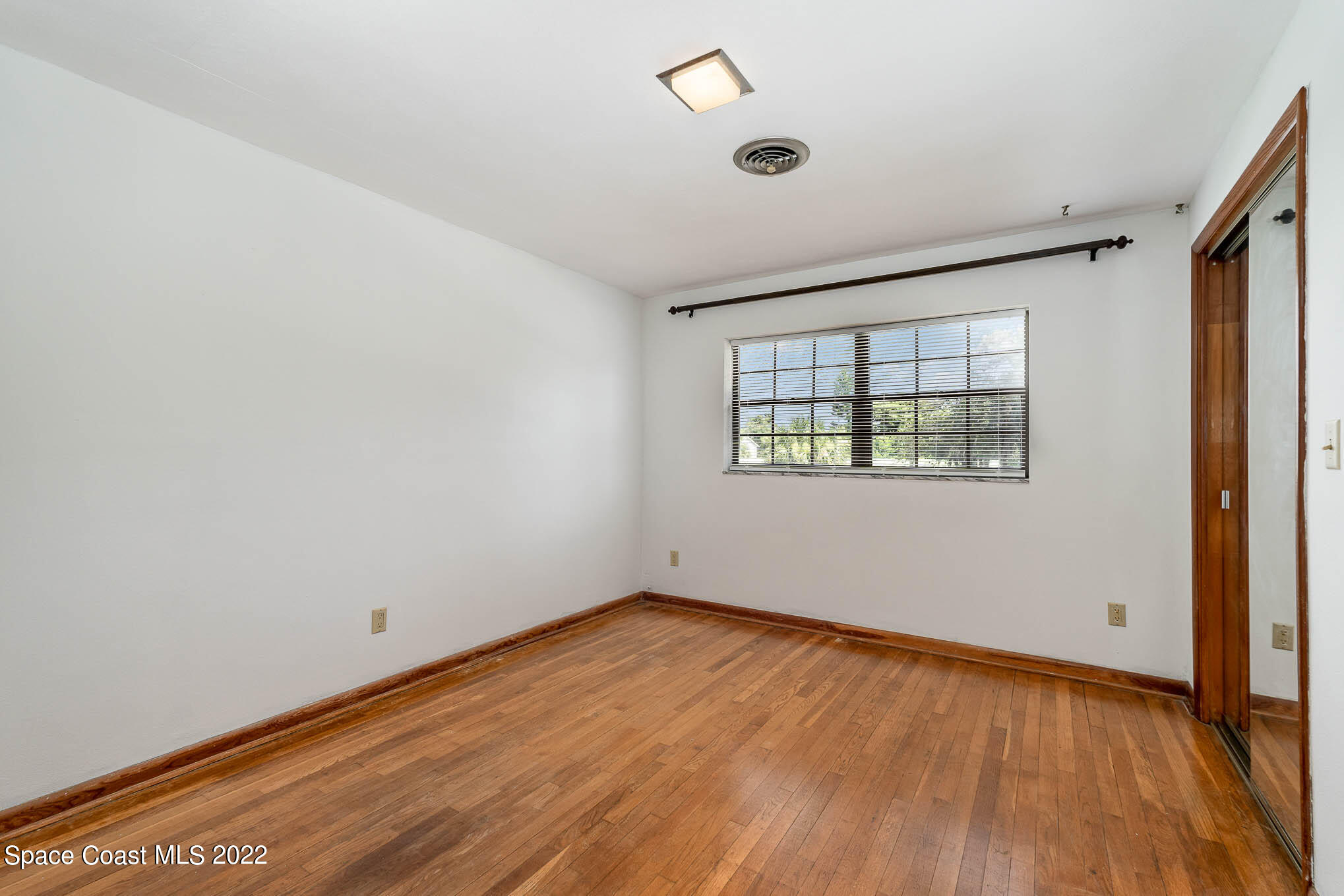 2676 Lemon Street Northeast Palm Bay, FL 32905 - Photo 23 of 35 an empty room with wooden floor and windows