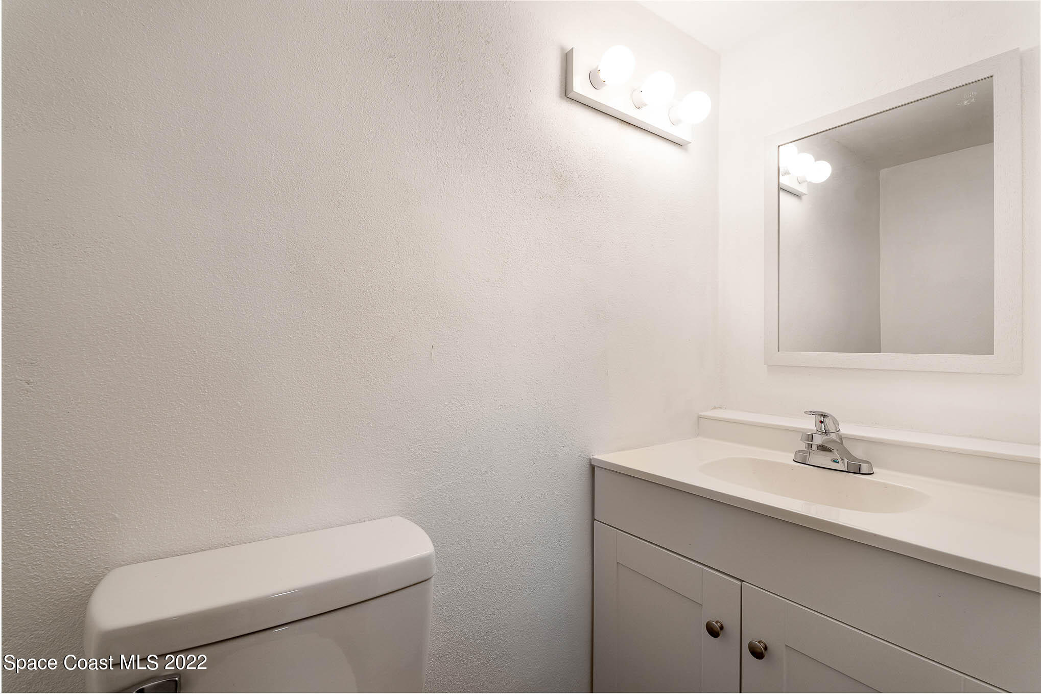 2676 Lemon Street Northeast Palm Bay, FL 32905 - Photo 28 of 35 a bathroom with a toilet a sink and mirror