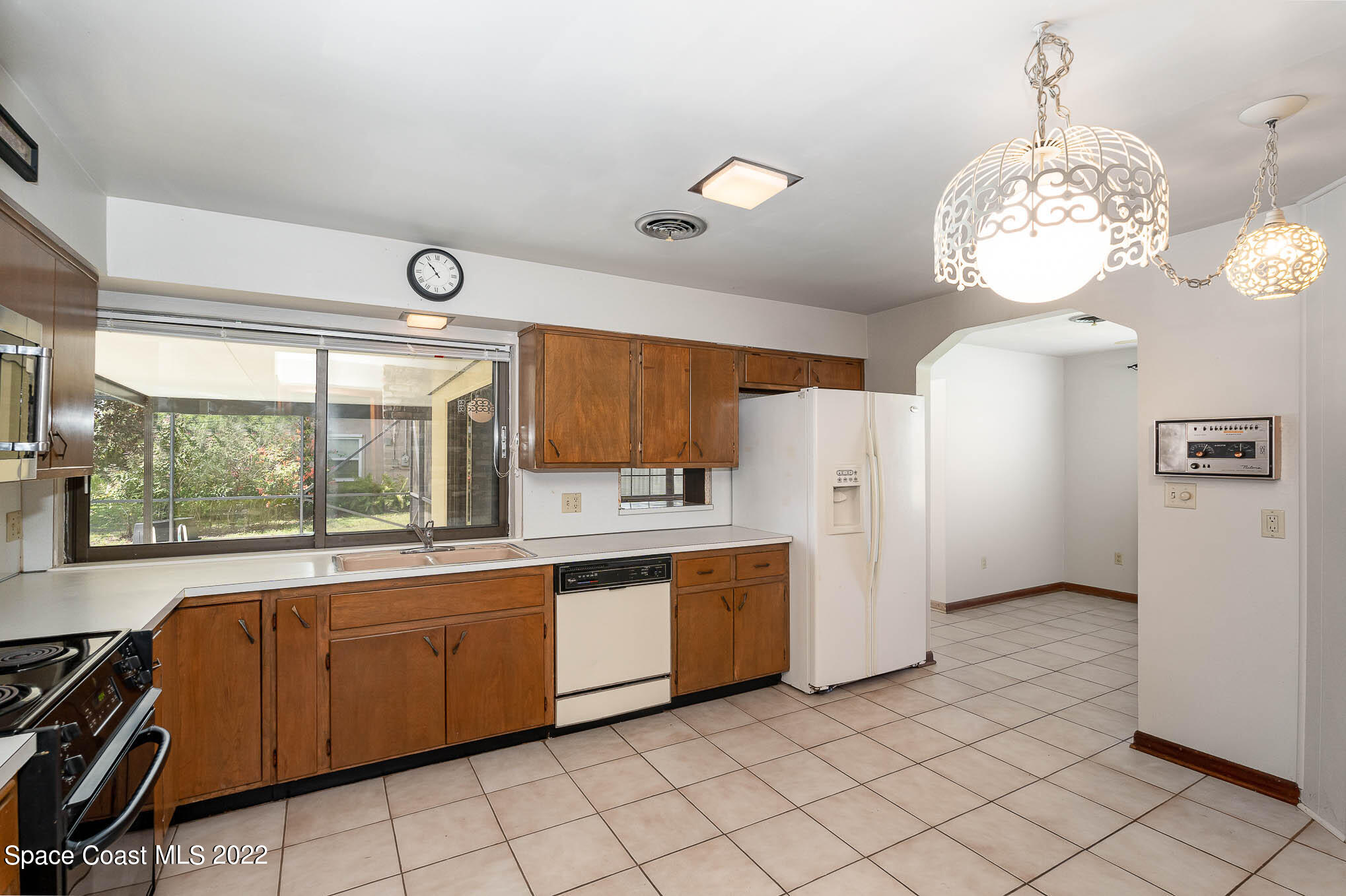 2676 Lemon Street Northeast Palm Bay, FL 32905 - Photo 7 of 35 a large kitchen with stainless steel appliances a large window cabinets and a chandelier