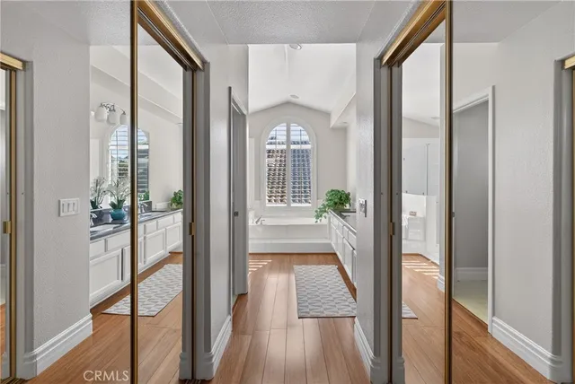 a bathroom with a granite countertop tub a sink and a large mirror
