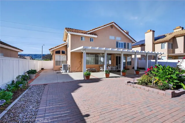 a view of a house with backyard sitting area and garden