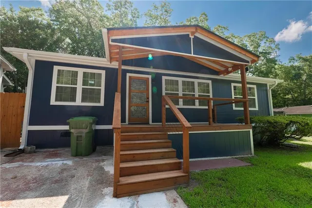 a front view of a house with a garden and plants