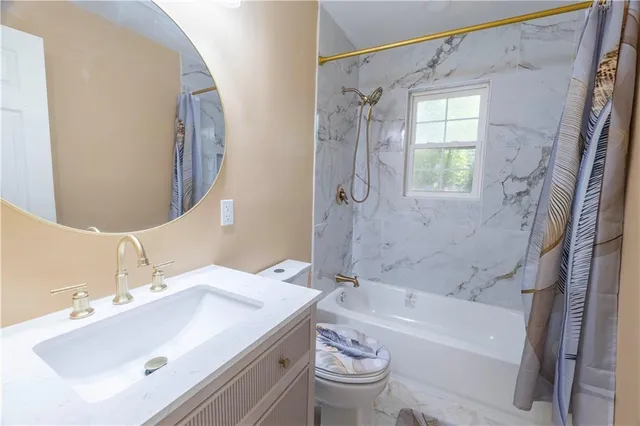 a bathroom with a sink toilet tub and shower